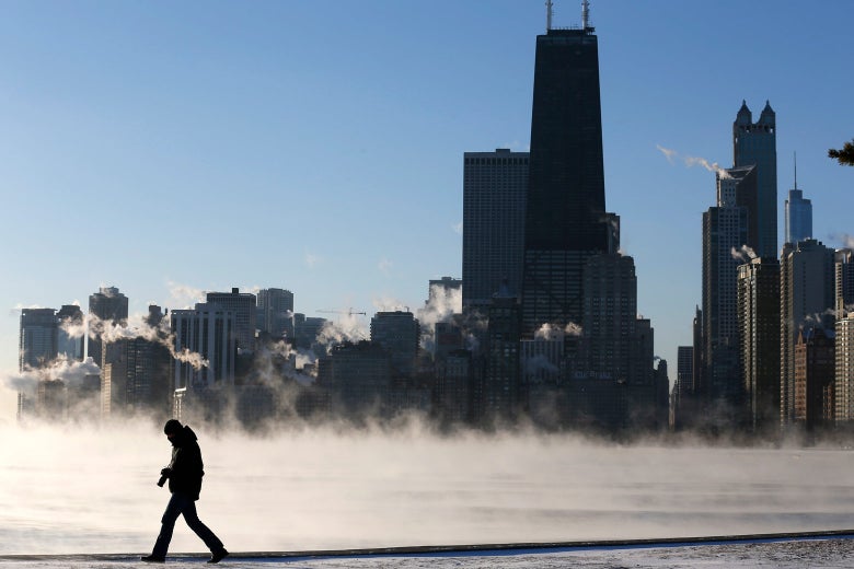 A man is silhouetted against the smoke rising off Lake Michigan.